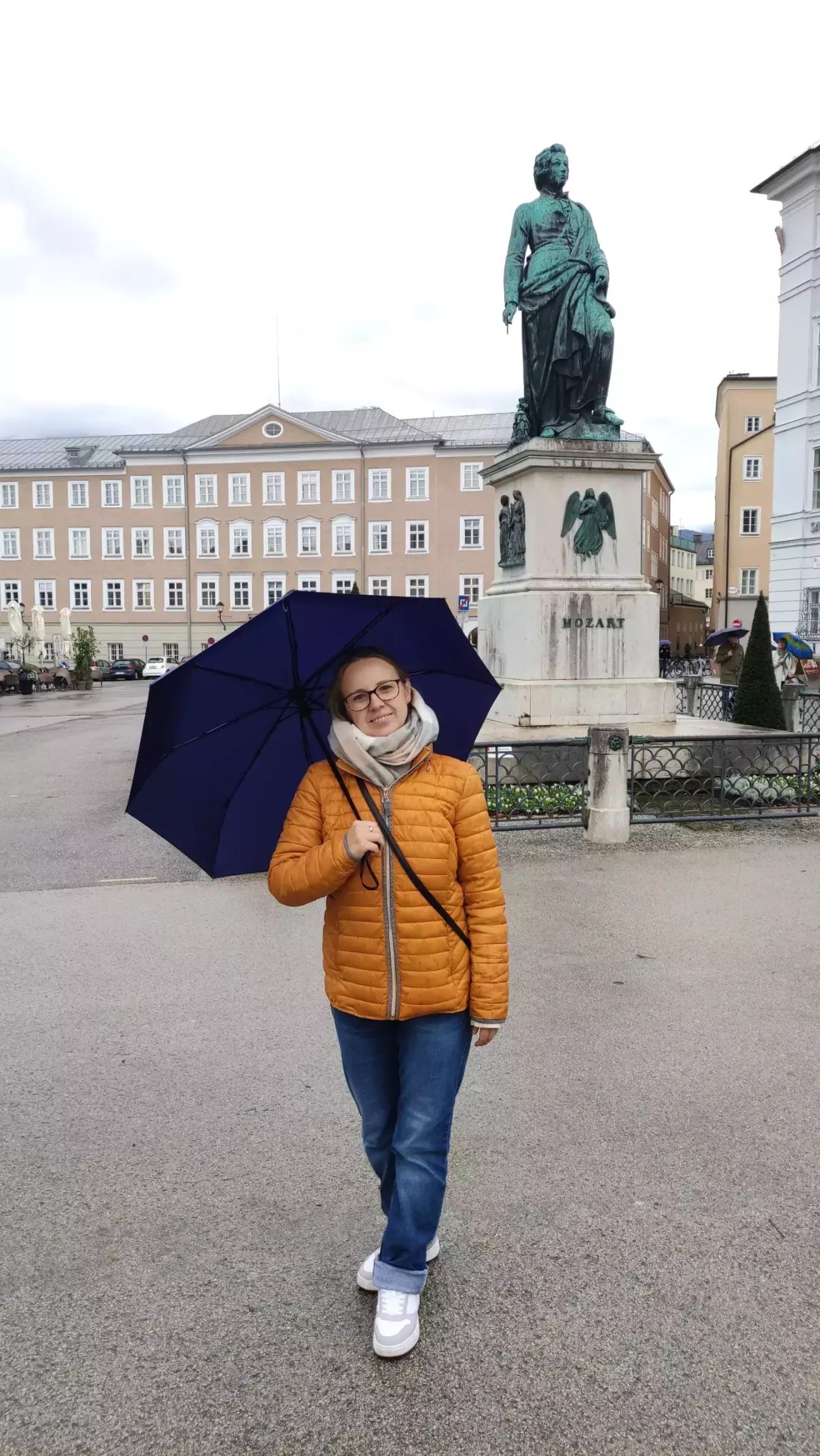 дружина позує на тлі пам'ятника Моцарту