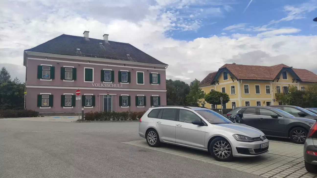 Гольф позує на фоні старої шкільної будівлі