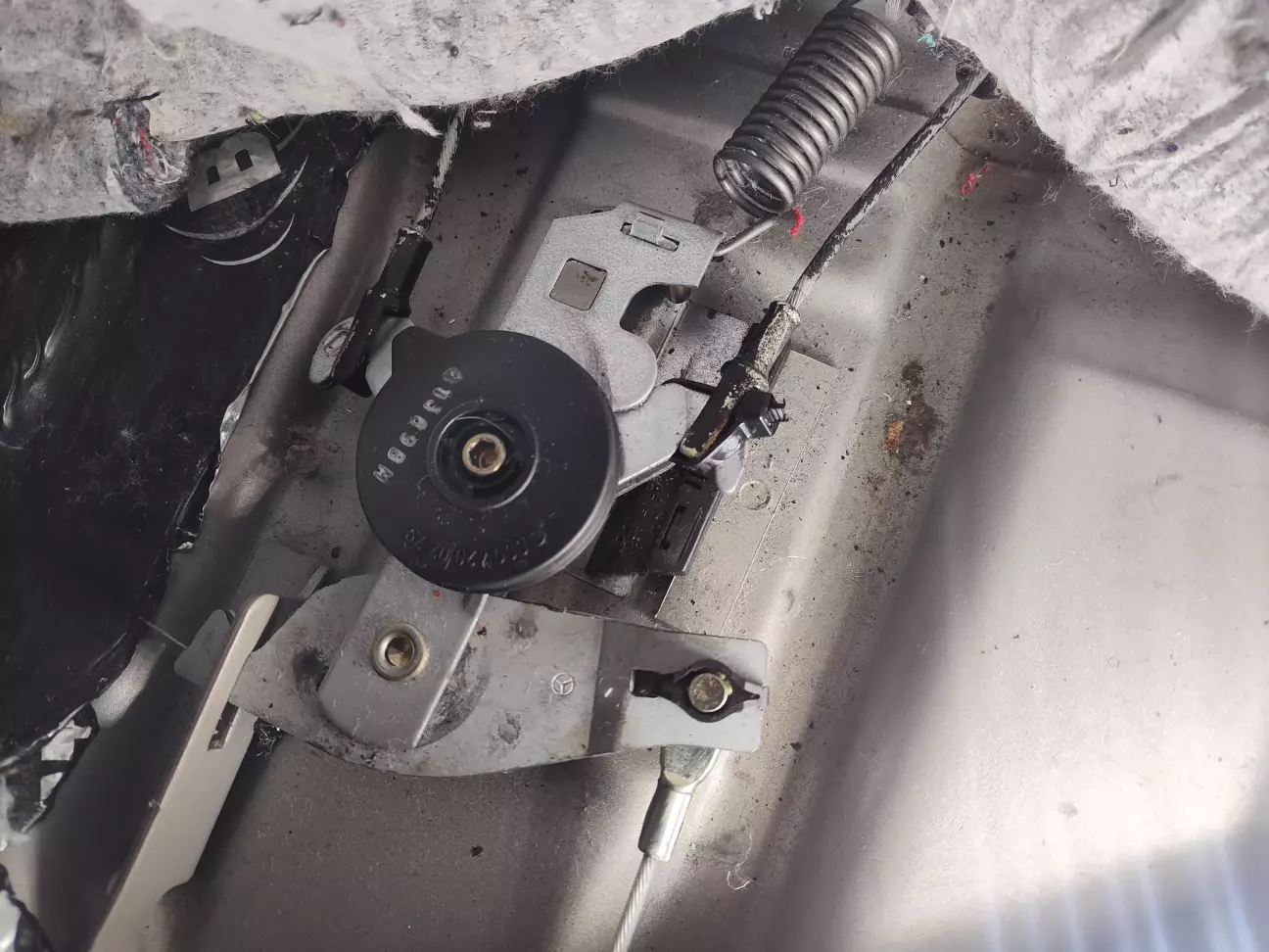 Трос ручного тормоза під сідушкою